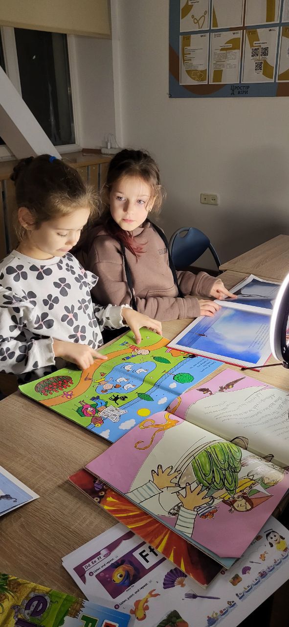 Children reading books donated by UK schools